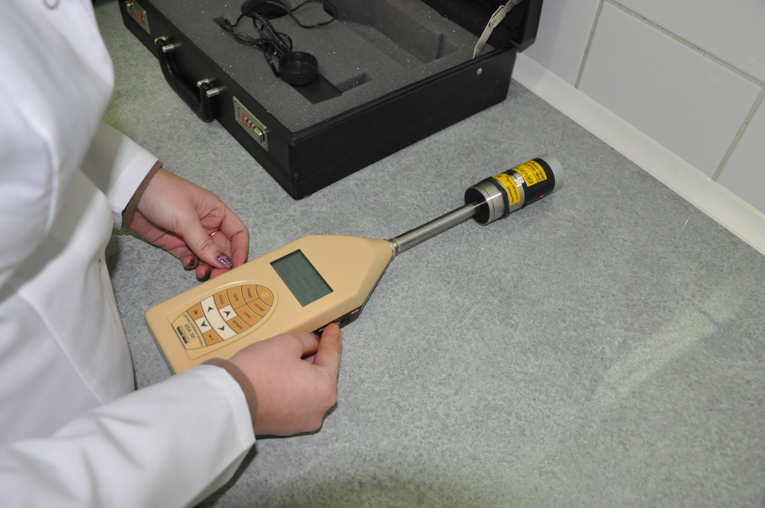 Specjalistka laboratorium Biochemik wykonująca pomiar środowiska pracy przy użyciu miernika poziomu dźwięku.